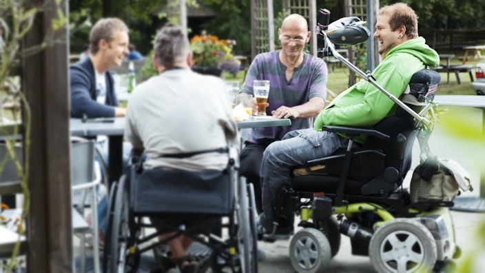 Group of friends in wheelchairs meeting at a pub